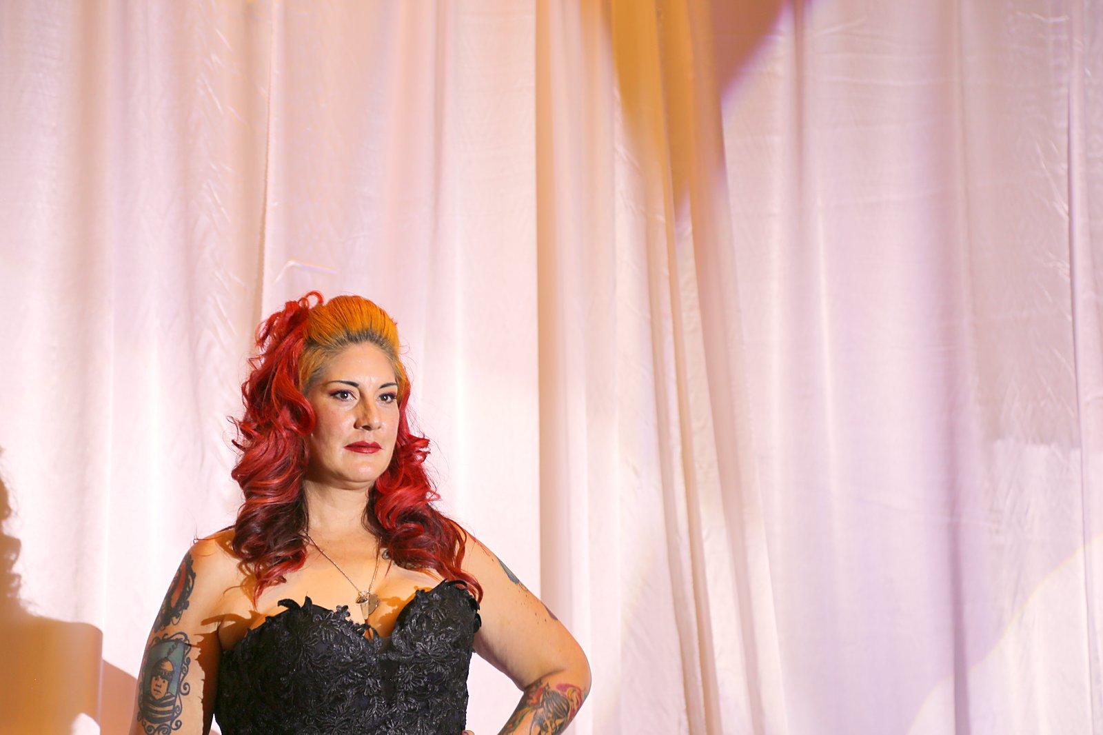 Model with a sculpted retro pompadour in copper and crimson with bold makeup